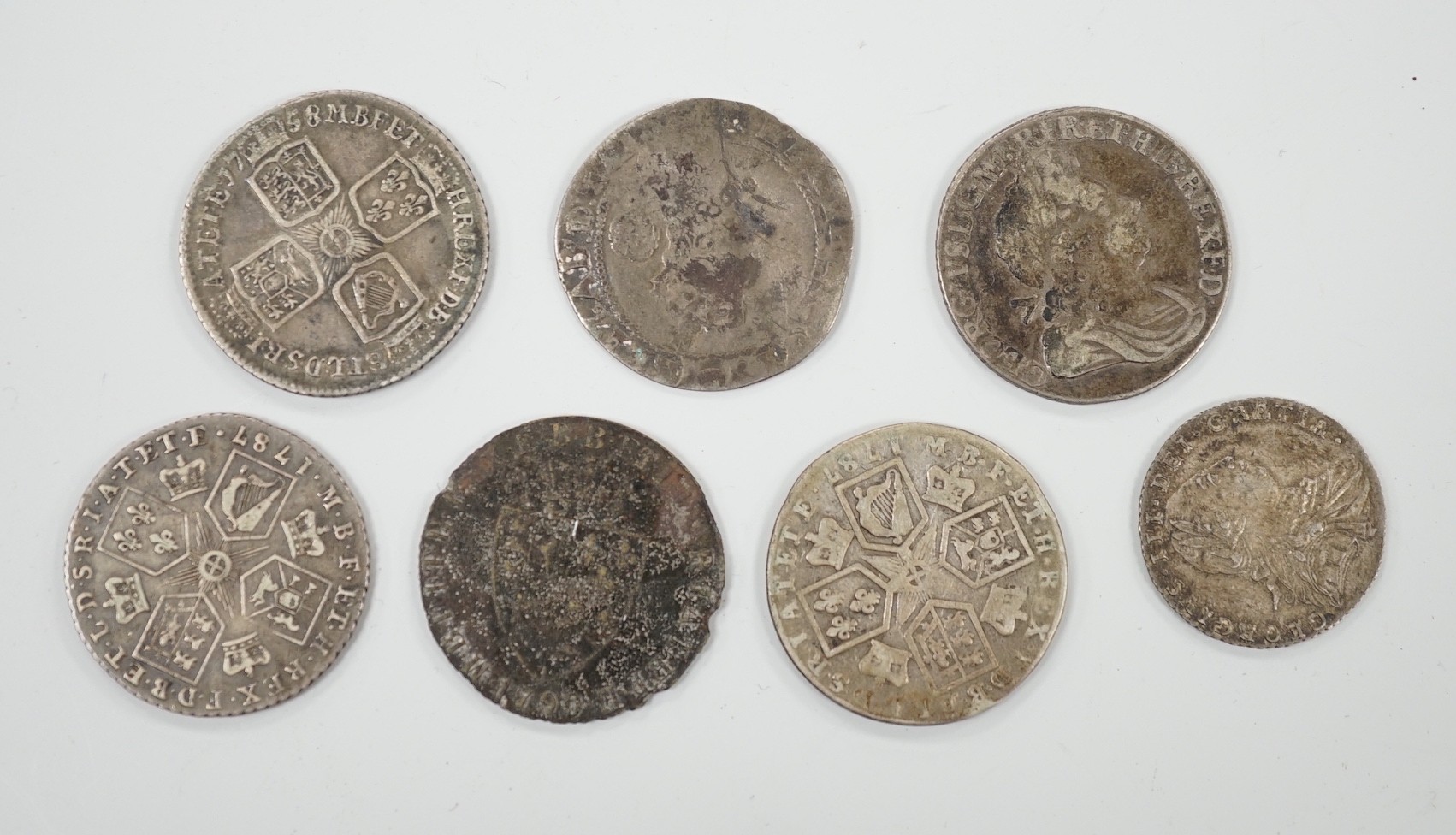 Four 18th century shillings, a sixpence an Elizabeth I coin and a token